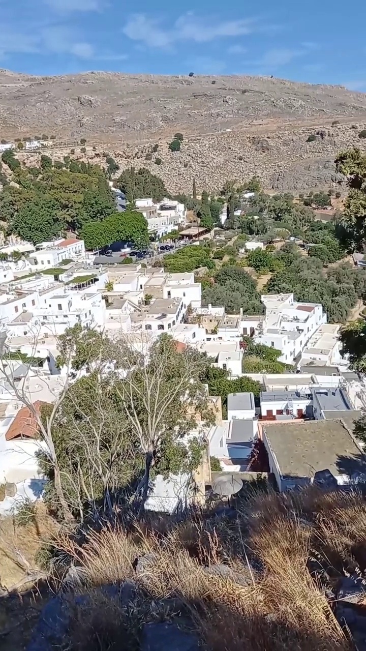 彩色垂直视频，在希腊的十二世纪，罗德岛上的古老城镇林多斯，在前往希腊最古老的卫城之一林多斯卫城的路上。