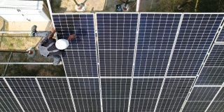 图为男工人正在安装光伏太阳能电池板。