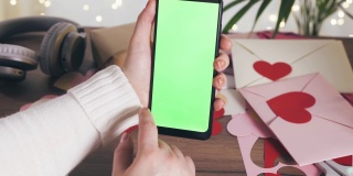 女性手持智能手机，绿色屏幕