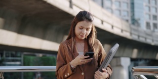 亚洲成功女商人在城市使用智能手机