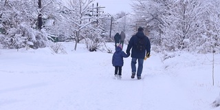 冬天的一天，爸爸和女儿在雪地里散步。冬天的乐趣