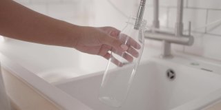 用手在可重复使用的瓶子里灌水的特写镜头