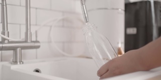 用手在可重复使用的瓶子里灌水的特写镜头