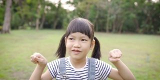 年轻快乐的亚洲小女孩有乐趣的肖像在公园