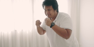 亚洲男子在家里进行拳击锻炼减肥