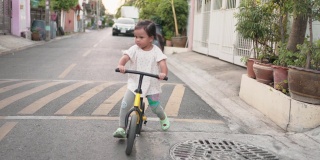 一个亚洲小女孩喜欢在街上骑儿童自行车