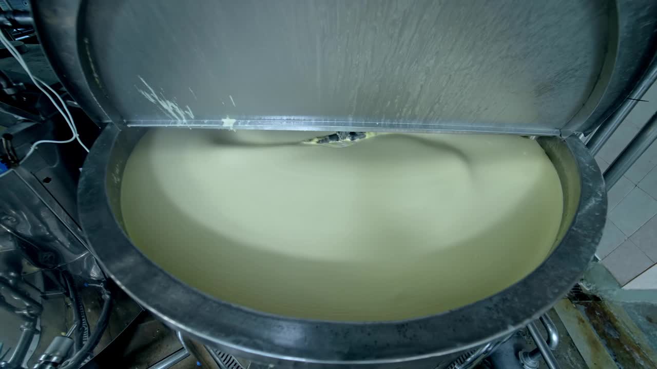 生产黄油的工业设备。现代化的容器在牛奶厂搅拌黄油。在罐中放入乳脂制品。