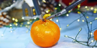 圣诞节剥橘子皮的新技术。用现代高科技设备准备新年。特写镜头。