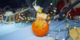 剥橘子的高科技设备。圣诞装饰背景上的金属控制工具。未来的创新。