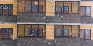 在一个大雪纷飞的冬天，城市里某公寓大楼的窗户前下起了一场大雪。雪花飘落得很快
