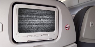 飞机座位上的白色液晶屏幕打开了色度键绿色屏幕有噪音。放大。近距离拍摄，4K分辨率。
