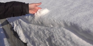一个人用手把雪抛掉。手在雪地里平稳地移动。