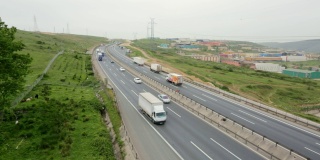高速公路上，卡车和汽车从镜头前经过。