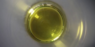 透明黄色油在玻璃化学试管的特写