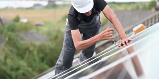 在屋顶安装光伏太阳能板的工人