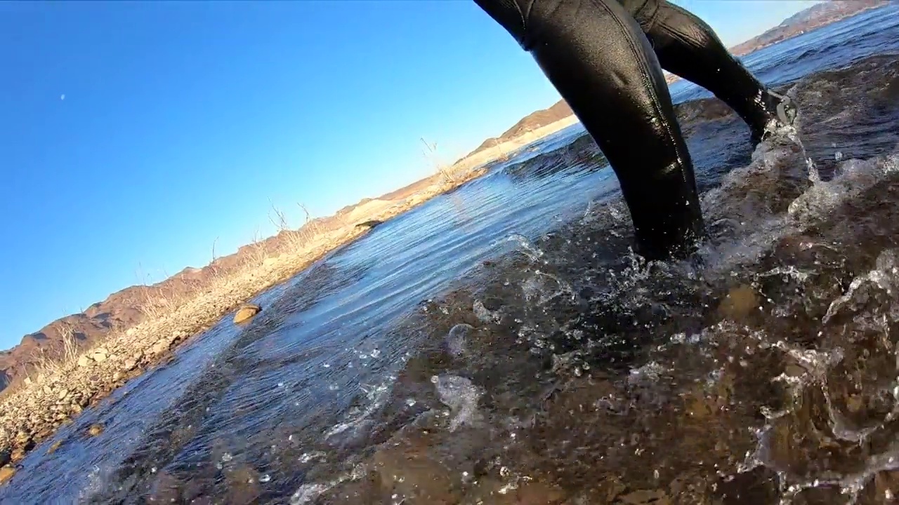 穿潜水服的靴子在浅水湖上拖着脚走