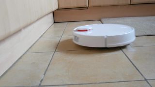 白色智能吸尘器清扫家里厨房的瓷砖地板。现代科技使生活更容易。特殊视频接收荷兰角视频素材模板下载