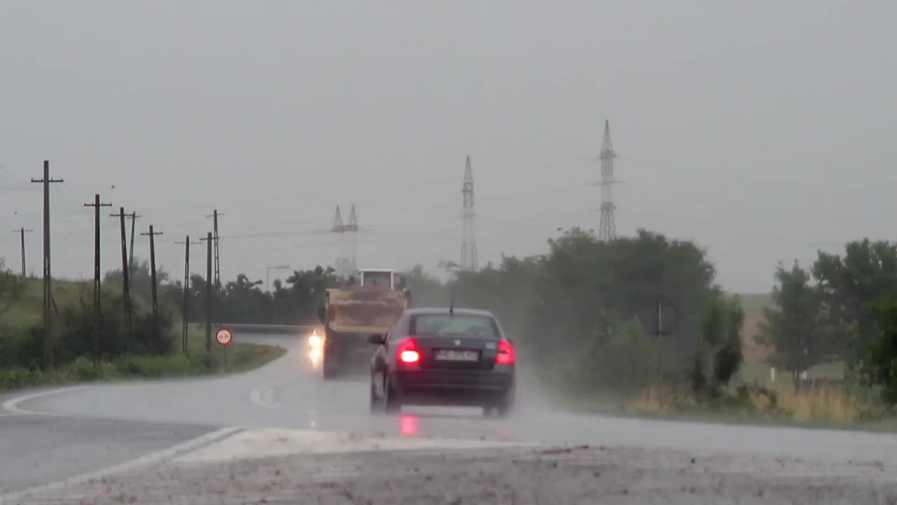 由于夏季大雨，卡车和小型汽车在潮湿的道路上行驶
