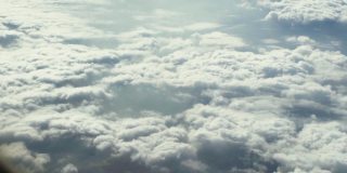 从飞机窗口俯瞰蓝天云层，这是令人惊叹的鸟瞰图。