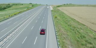 航拍，慢镜头红色四驱车行驶在空无一人的高速公路上。