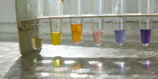 医学试管在实验室与彩色液态水在实验室与试剂的窗口与大理石窗台。