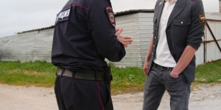 两个俄罗斯警察在乡间的小路上微笑着交谈着。