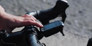 自行车计算机导航器。现代技术。在自行车车把上使用GPS导航的女人。骑行途中检查骑行电脑。GPS路径规划