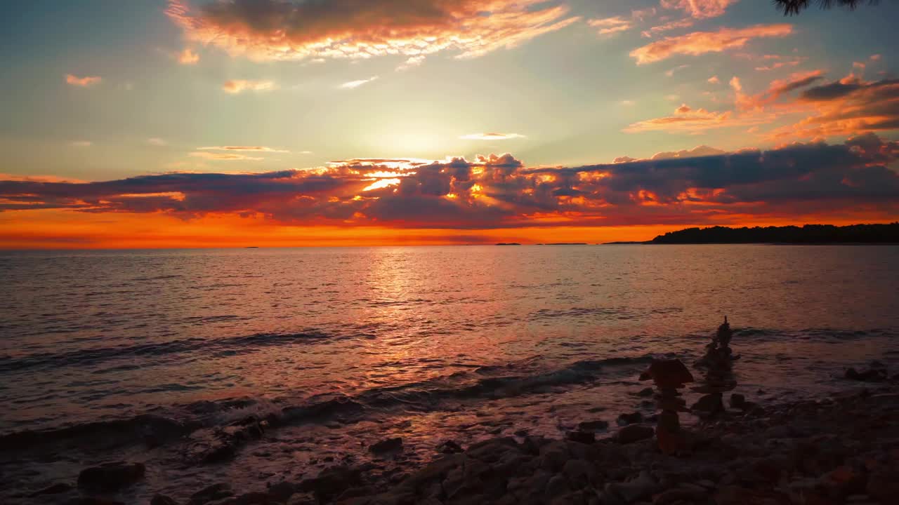 随着时间的推移，在风景优美的自然浪漫的平静的海水海滩上，太阳从地平线落下，克罗地亚地中海海滨的小波浪像一个大的橙色球。户外旅游度假日落cinemagraph无缝视频循环im 4K超高清。