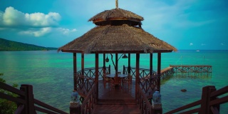 美丽的Cinemagraph /无缝视频循环的一个豪华的热带海滨度假胜地与一个餐厅亭的蓝色/蓝绿色的海边水和珊瑚礁在亚洲的热带岛屿天堂。
