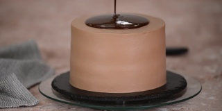 把巧克力酱倒在美味的蛋糕上，特写镜头。