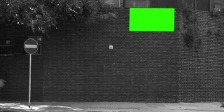 空白广告牌或广告牌与绿色屏幕的砖墙上的房子在阿根廷。黑白色调。