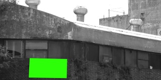 旧工厂墙上的空白广告牌或有绿色屏幕的广告牌。黑白色调。