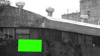 旧工厂墙上的空白广告牌或有绿色屏幕的广告牌。黑白色调。视频素材模板下载