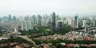 印尼雅加达，一架无人机从右向左飞行，拍摄了拥挤的住宅区附近摩天大楼的美丽航拍照片。拍摄分辨率为4k