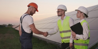在太阳能农场，工头和检查员握手问候。