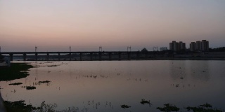 从白天到晚上，萨巴尔马蒂河和桥的时间推移，在河边，艾哈迈达巴德城市在黄昏。美丽发达的城市，印度古吉拉特邦。