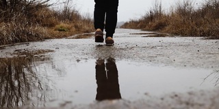 秋雨中，女人们穿着运动鞋在水坑上跳跃行走