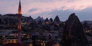 土耳其卡帕多西亚，戈雷米的夜景，夕阳西下，俯瞰着尖塔和岩石中的房屋