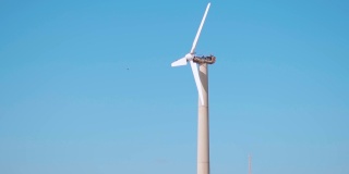 在湛蓝的天空背景下拍摄的风车特写，用于发电的风车。在印度古吉拉特邦库奇的曼dvi海滩
