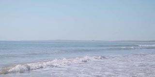 小海浪的慢动作视频打破在Mandvi海滩，库奇，印度的沙滩。热带海滩夏季度假的自然背景。海滩旅游度假