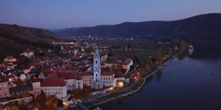 邓恩斯坦镇和葡萄园的夜间空中全景图。奥地利Wachau山谷，从24帧加速到2.5倍。