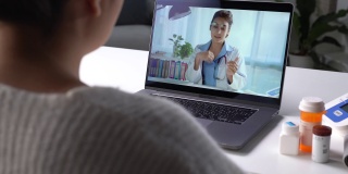 亚洲女患者在电脑上的网络摄像头会议上与医生在线交谈咨询。