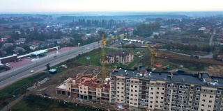 新建多层住宅建筑。两台塔式起重机正在完成最后一段。从鸟瞰的角度拍摄。