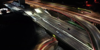 夜间空中立交桥交通拥堵立交道路，夜间无人机拍摄下现代城市道路交叉口的俯视图。许多汽车在繁忙的十字路口高速公路快速行驶