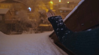 女人的手试图抓住雪，而落在晚上视频素材模板下载