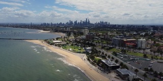圣基尔达海滩，墨尔本，维多利亚，澳大利亚显示CBD城市天际线和菲利普湾港口海岸线。空中无人机视频