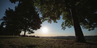 日落在环绕着Forlì，意大利Emilia-Romagna的山丘上的干草地上。