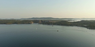 克罗地亚Sibenik市附近的Kornati岛上空的无人机日落。水湾与船和柔和的阳光。