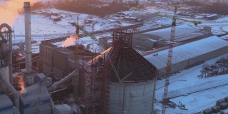 日落时分，工业生产区水泥塔与高混凝土厂房结构的鸟瞰图。制造业和全球产业理念