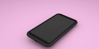 一部黑色的智能手机掉在粉色的桌面上，弹起来不会摔坏